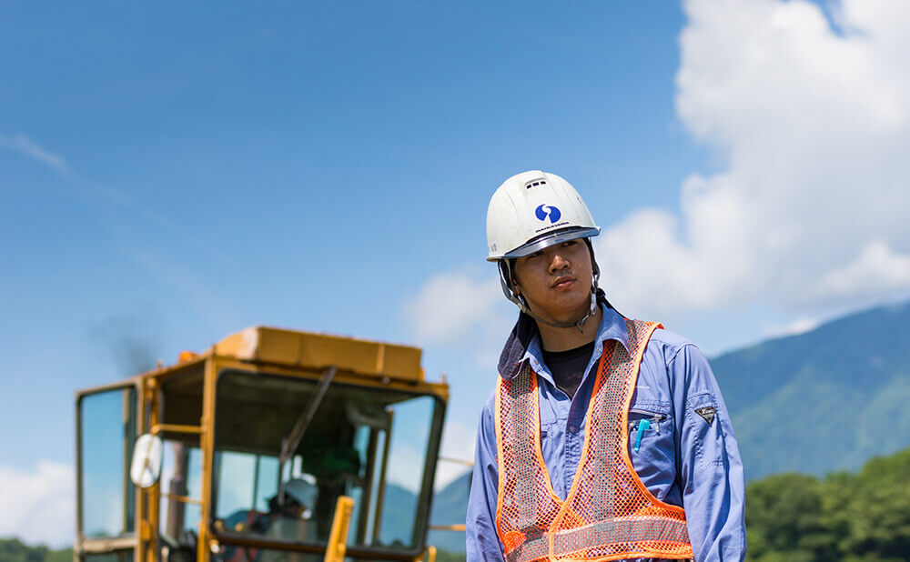 作業服を着て空を見上げる男性